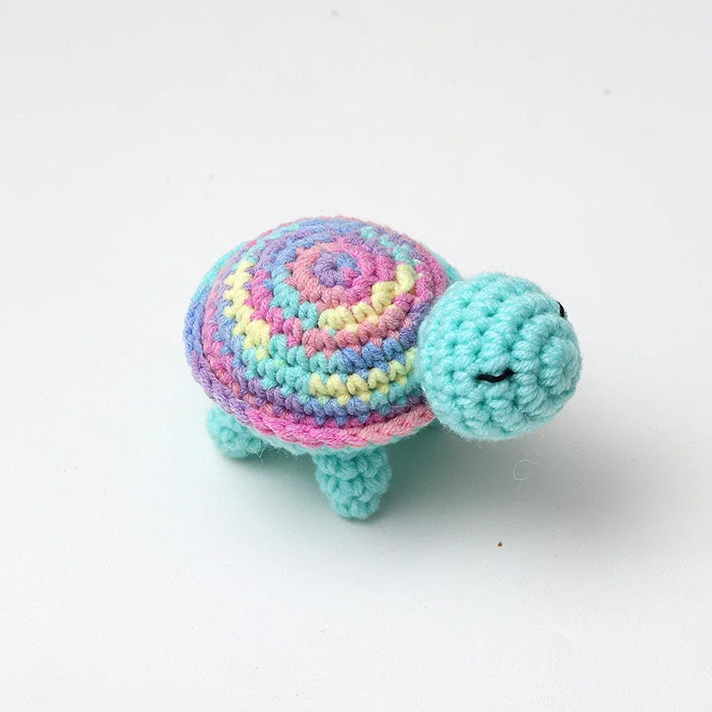 Handmade crocheted turtle plush with colorful patterned shell and blue head