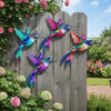 Vintage metal hummingbird wall art featuring vibrant iridescent colors against a weathered wooden fence.