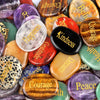A collection of polished natural crystal ellipses in various colors including purple, orange, green, and black.