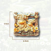 A wooden souvenir featuring two shaggy Highland cows and flowers, labeled Scotland.
