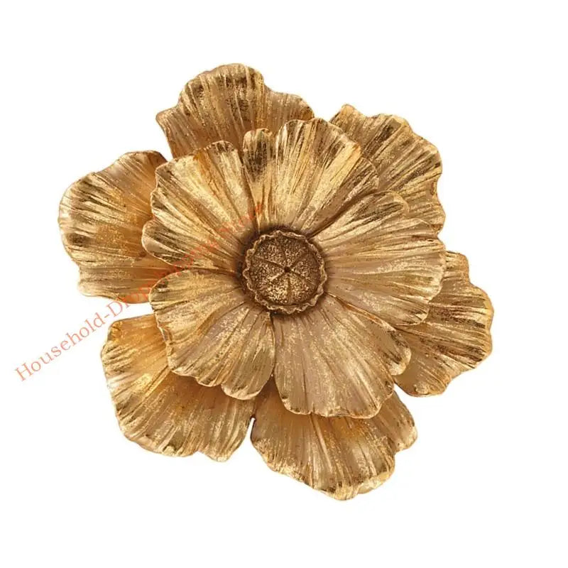 A close-up of a golden, layered resin floral piece used as wall decor.