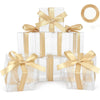 A stack of clear PET favor boxes tied with gold ribbons and featuring a circular tag.