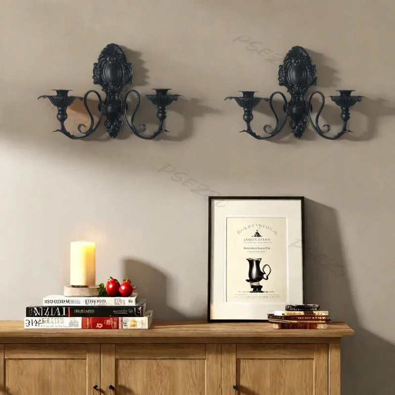 Vintage black wall pendant candle holder mounted on a beige wall above a wooden cabinet.