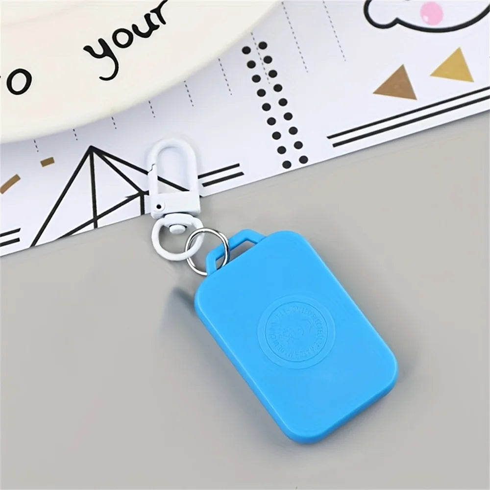 A bright blue LED keychain pocket watch with a silver clasp is shown resting on a piece of lined paper.