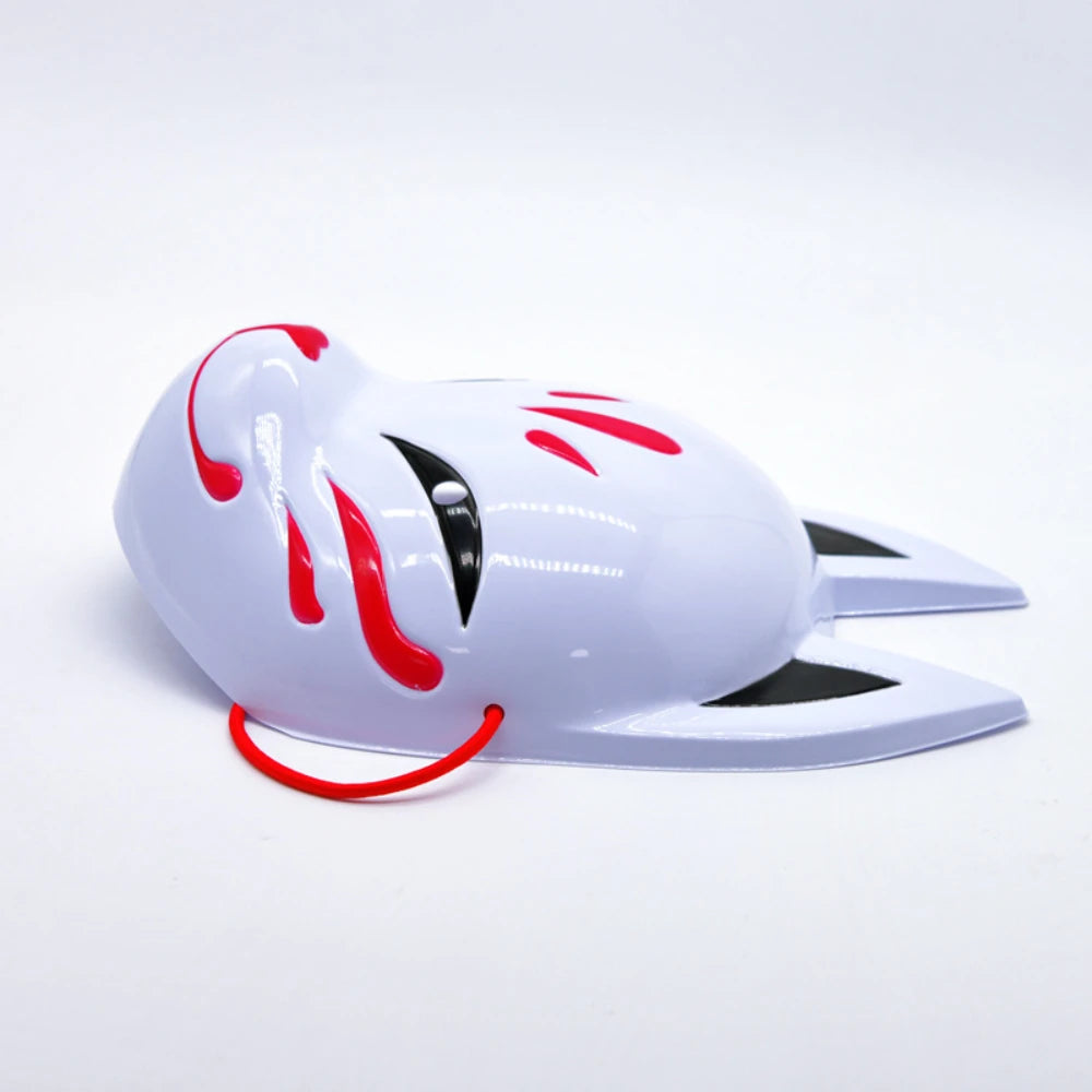 A white fox face mask with red accents and black markings, displayed against a white background.