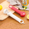 A white ergonomic jar and bottle opener set with a red handle rests on a wooden board next to a cloth and citrus fruits.