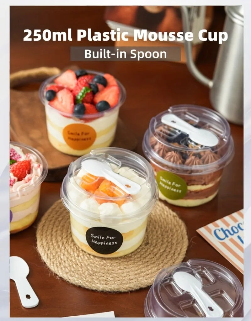 A clear plastic mousse cup with a built-in spoon filled with a creamy dessert on a woven mat.