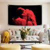 A red silhouette of a woman's face and hair is displayed on a black tapestry hanging above a light-colored sofa.
