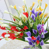 A vibrant bouquet of artificial calla lilies in shades of white, yellow, red, and purple.
