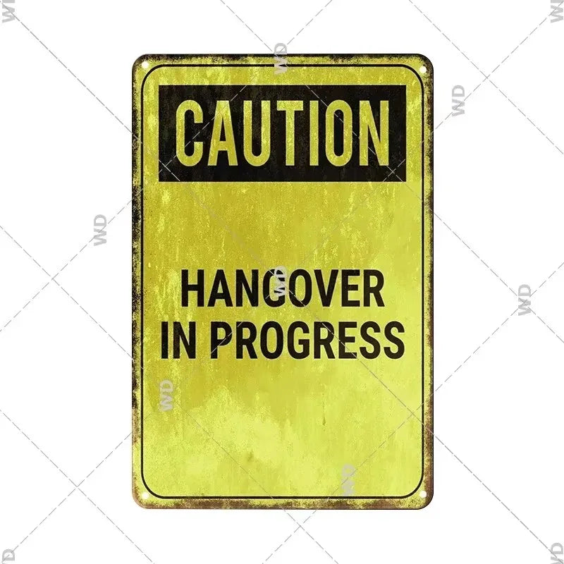 A yellow vintage tin sign with black text warning of a hangover in progress.