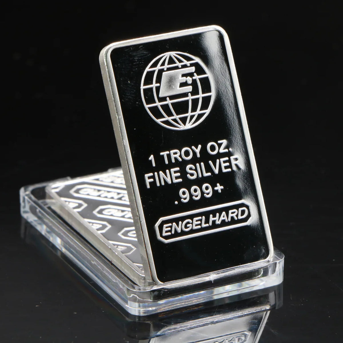 A silver bullion bar replica with a globe design and the text 1 Troy oz Fine Silver .999+ Engelhard