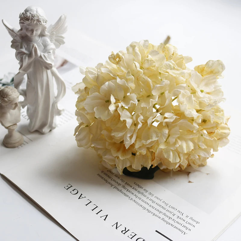 A bouquet of cream colored silk hydrangea stems with vintage burnt edge petals
