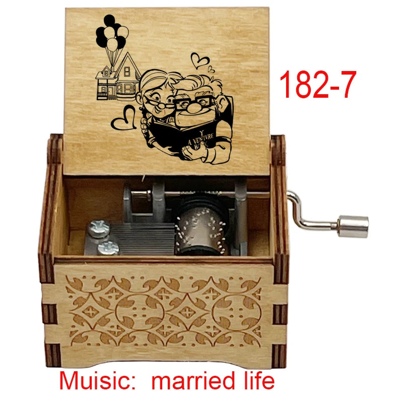 A wooden music box with a lid featuring a cartoon couple and an open side revealing a hand crank mechanism.