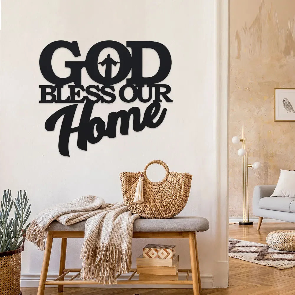 Art de métal noir avec le texte GOD BLESS OUR HOME, fixé sur un mur blanc.