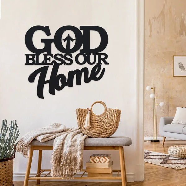 Arte de pared de metal negro con el texto "GOD BLESS OUR HOME" montado en una pared blanca.