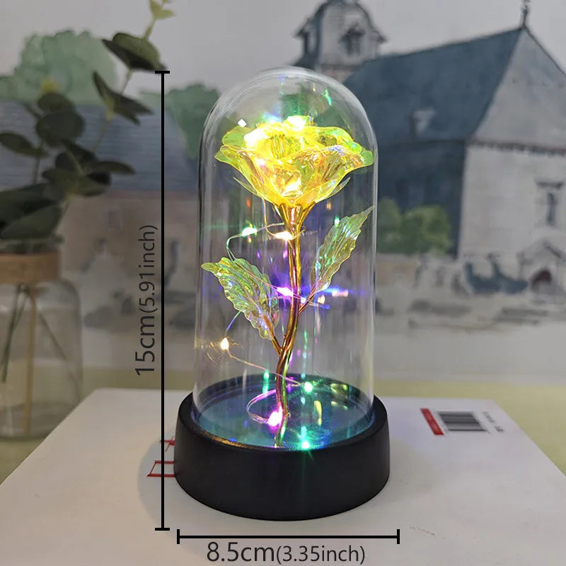 A glass dome containing a preserved rose with an LED light, displayed on a white surface.