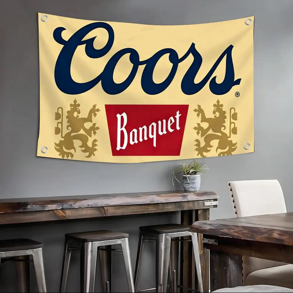 Gelbes Banner mit dem Wort Coors in dunkelblauer Schrift und dekorativem Laub an den Seiten