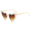 Pearl-embellished heart-shaped sunglasses with light beige frames and tinted lenses