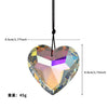 A clear crystal heart pendant with a faceted prism design hanging from a black cord.