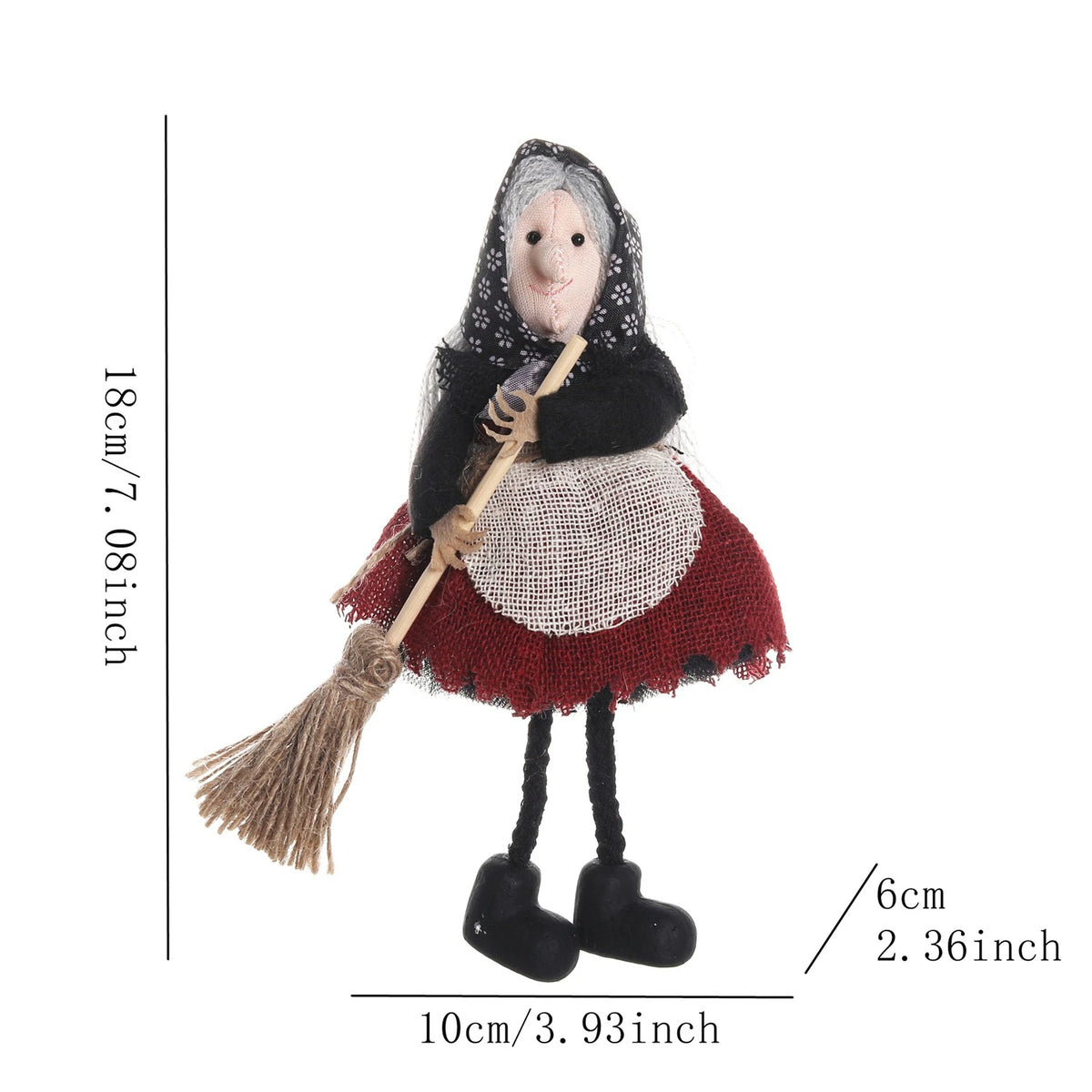 A small ornament featuring a scarecrow witch with gray hair, black clothing, and a straw broom.
