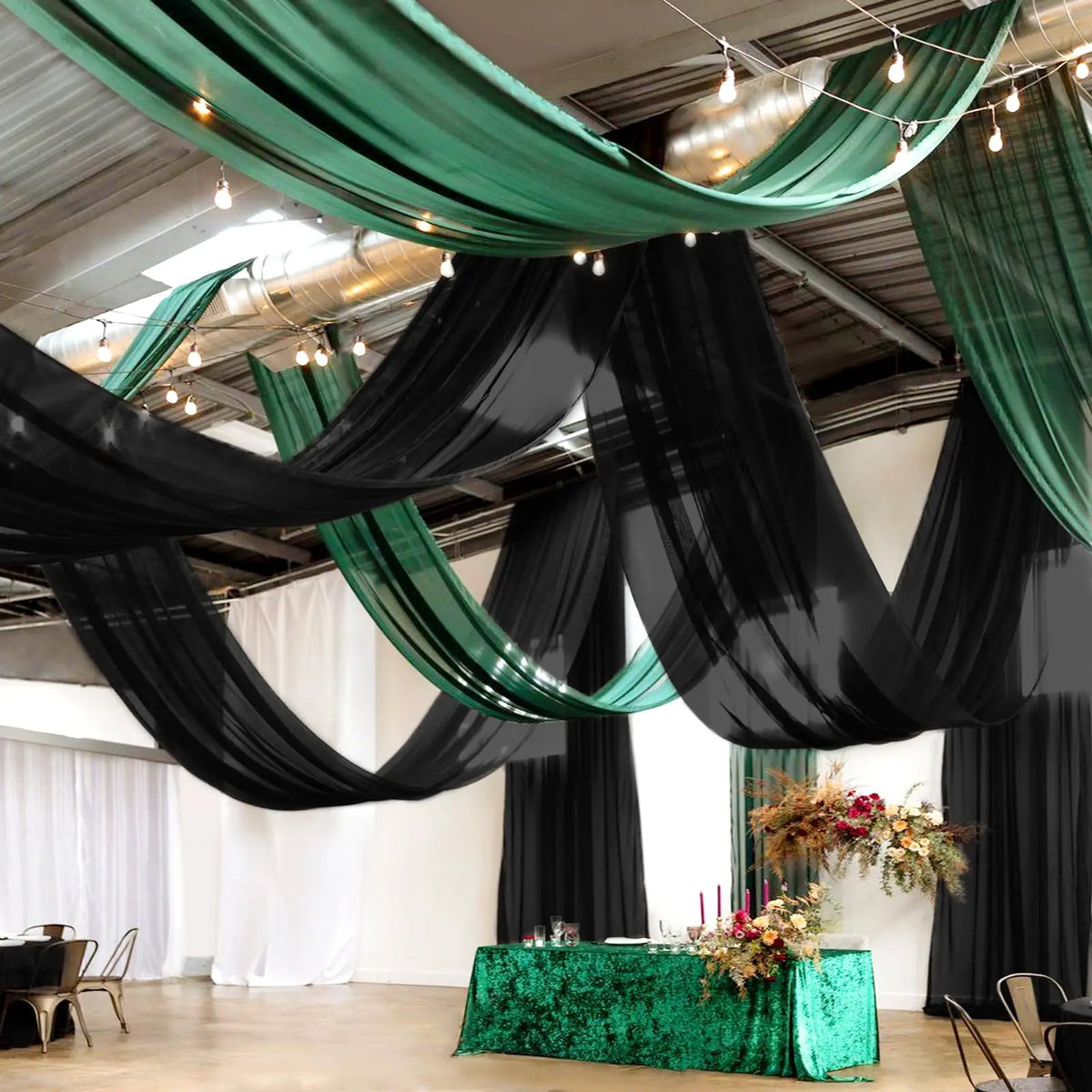 Dark green sheer chiffon curtains draped across an indoor event space.