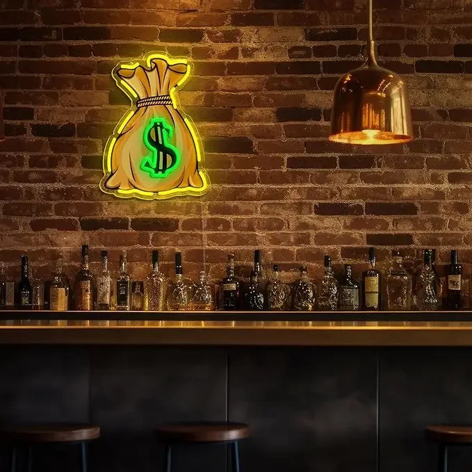 A neon dollar sign LED wall light is mounted on a brick wall above a wooden bar counter.
