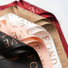 A stack of waterproof floral wrapping paper in shades of pink, beige, and deep red.