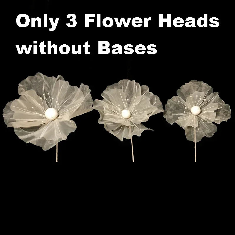 Three large, sheer beige flower heads without bases for wedding decoration.