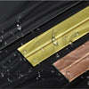 Close-up of self-adhesive PVC edge guard strips in gold and rose gold finishes against a dark surface.