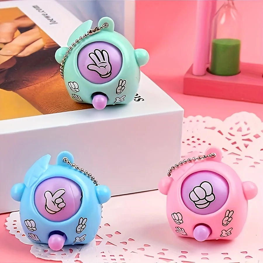 A set of three mini rock-paper-scissors themed keychains in teal, blue, and pink on a white box.