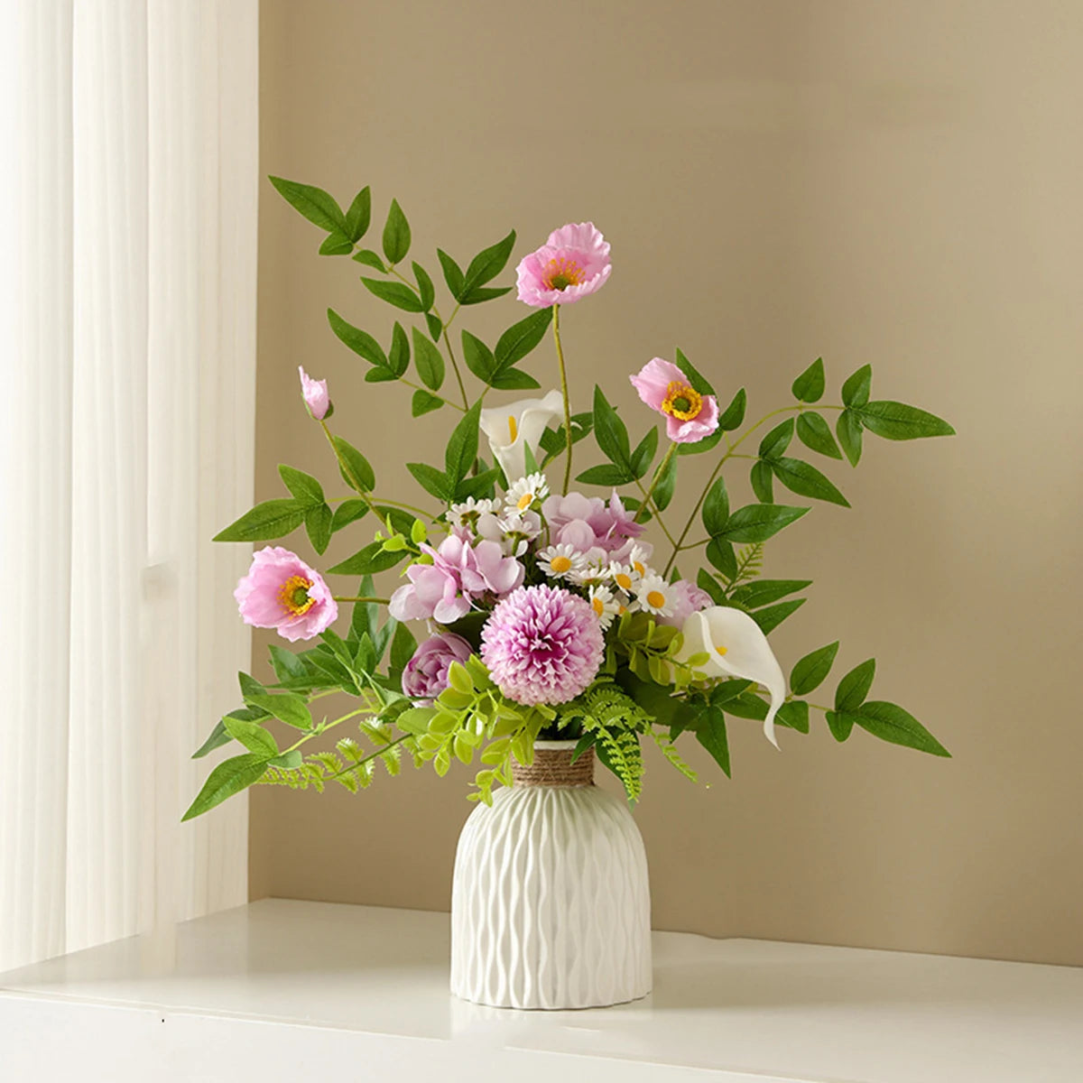 A bouquet of pink and white flowers in a white ceramic vase on a light-colored shelf.