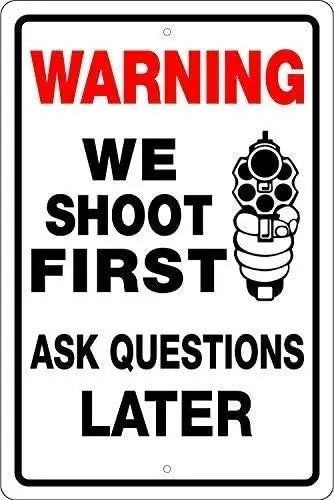 A white warning sign with red text instructing to shoot first and ask questions later.