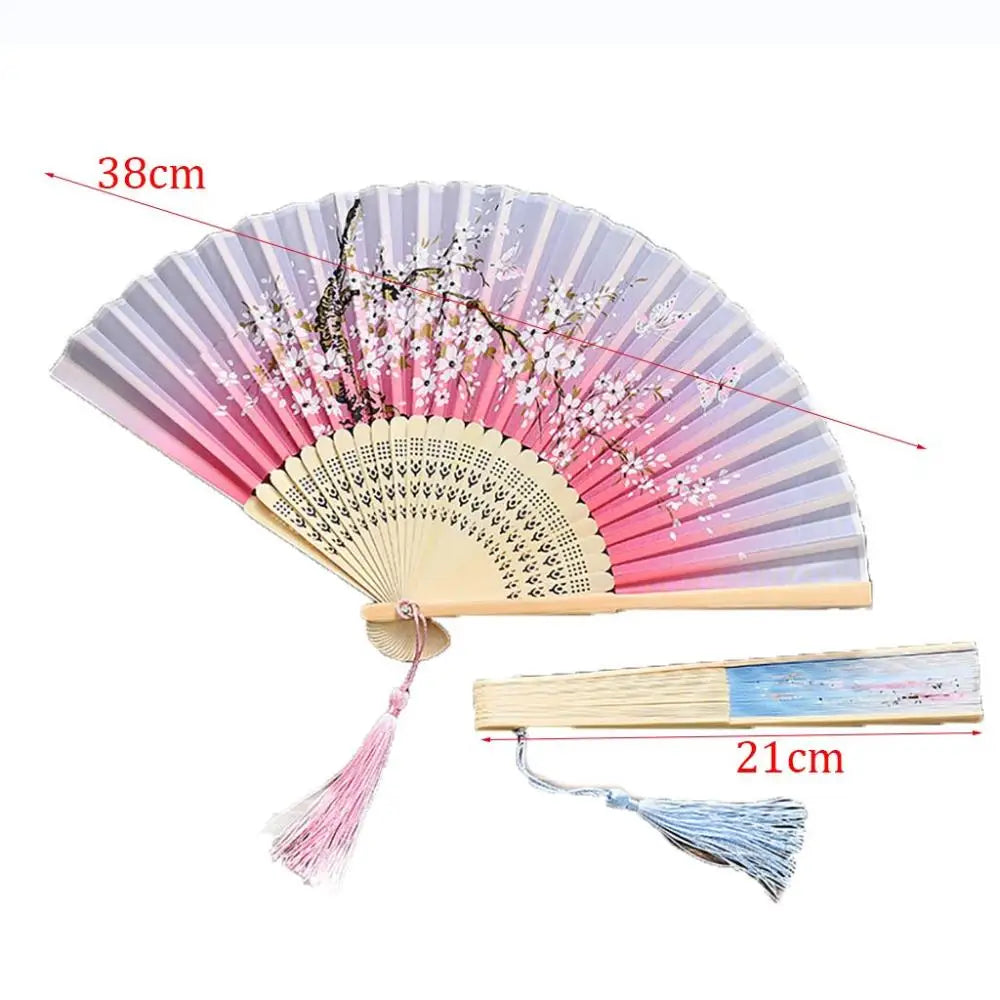 A vintage silk folding fan with pink and white oriental patterns, shown open and closed.