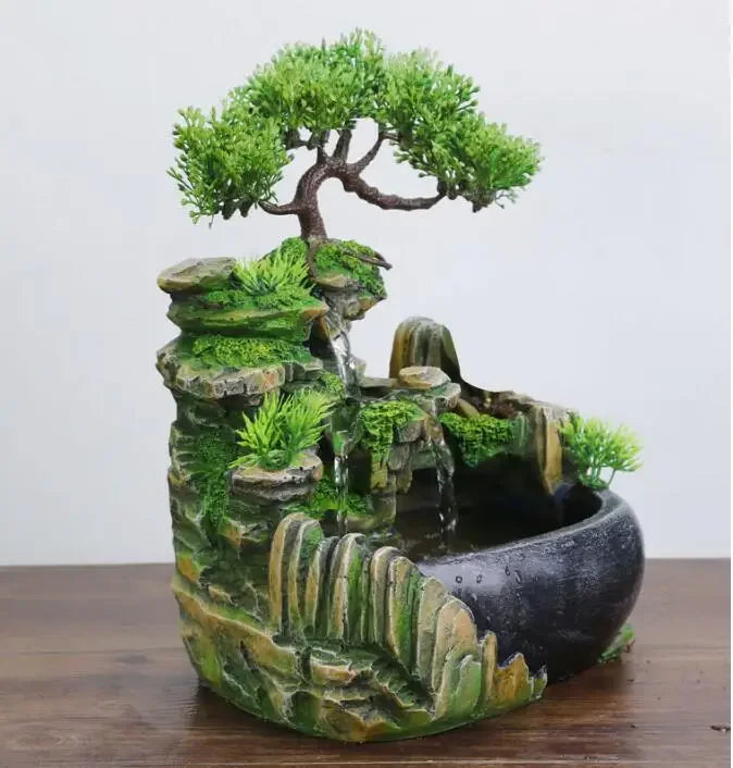 A resin desktop fountain featuring a mossy rock landscape with a small tree and flowing water.