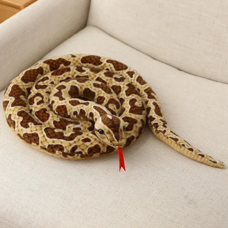 A realistic brown and yellow patterned snake plush toy coiled on a white surface.