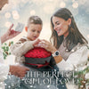 A woman and a boy are presenting a red rose bouquet in a heart-shaped gift box as a perfect gift of love.