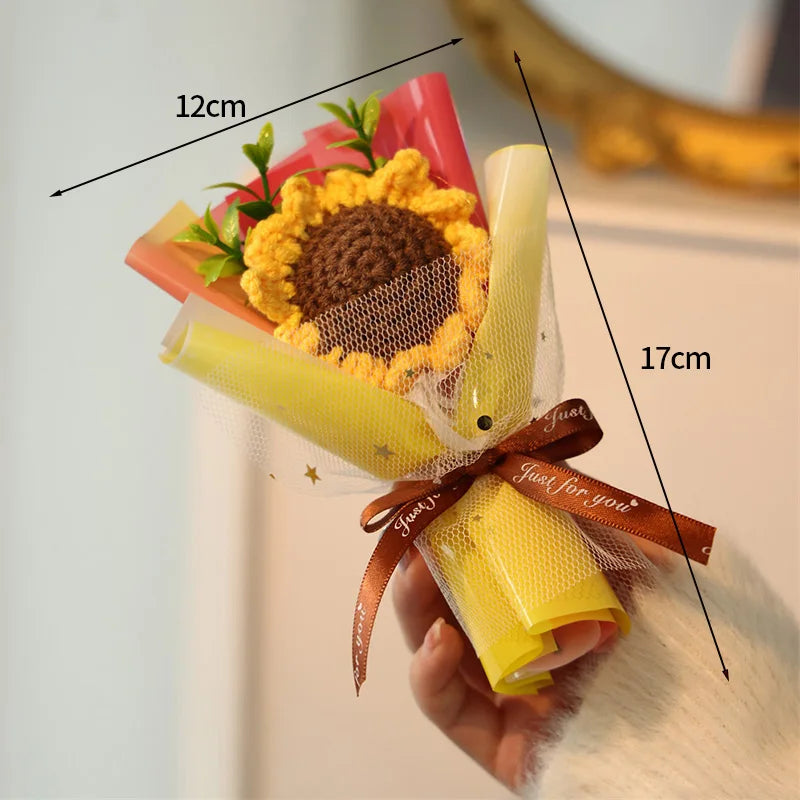 A handmade crochet flower bouquet featuring yellow and orange flowers wrapped in sheer netting and ribbon.