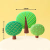 Three green jungle animal cake toppers shaped like trees, including a tall conical tree.