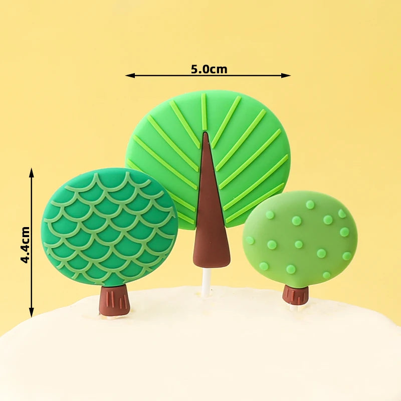 Three green jungle animal cake toppers shaped like trees, including a tall conical tree.