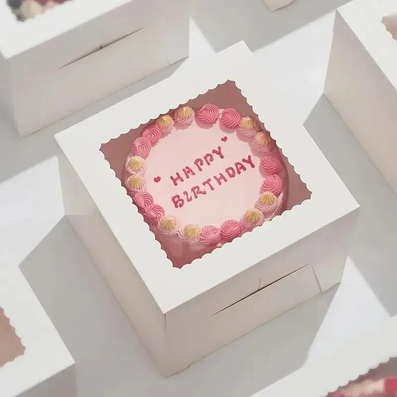A white bakery box with a pink floral design and the text Happy Birthday on the lid.