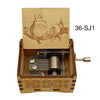 A wooden music box featuring an engraved anime character design and a mechanical mechanism.