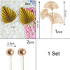 A set of golden palm leaf cake toppers featuring delicate flower decorations and spherical gold ornaments.