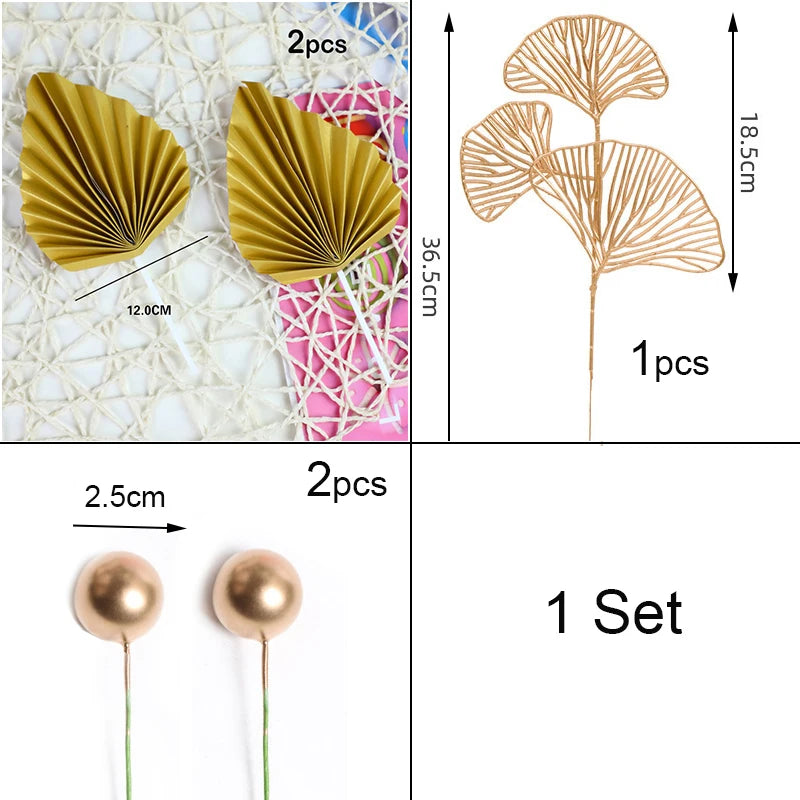 A set of golden palm leaf cake toppers featuring delicate flower decorations and spherical gold ornaments.