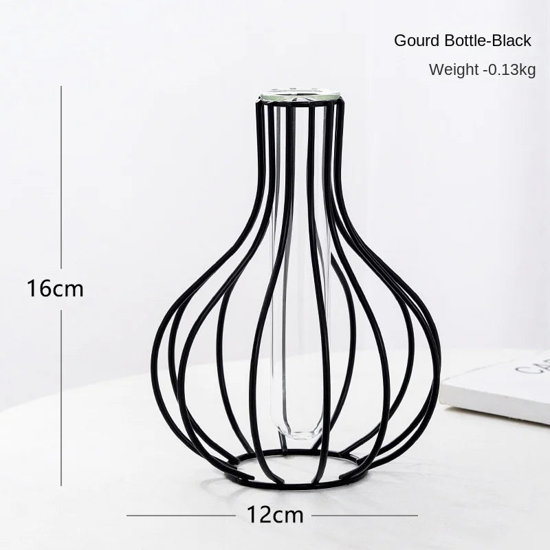 A black iron hollow vase with a slender neck and flared base, shown against a white background.