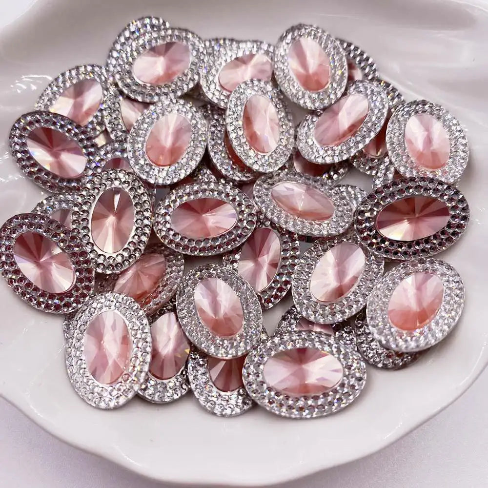 A collection of pink and clear gemstone flatback rhinestones arranged on a white dish.
