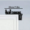 Black metal wall art featuring silhouettes of two praying figures and the word THINKING BOOM
