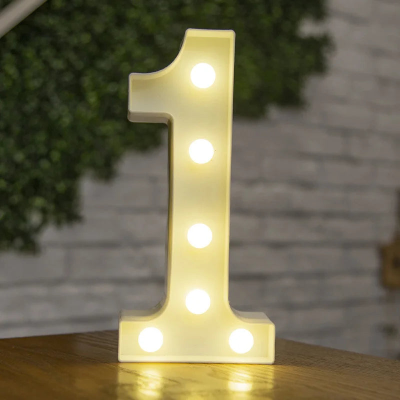 A glowing warm white LED alphabet letter light shaped like the number one on a wooden surface.