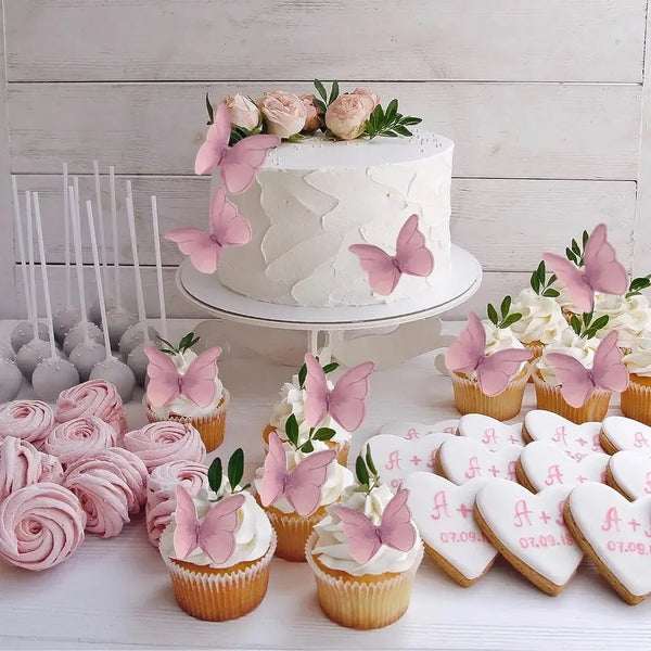A display of pink butterfly cupcake toppers and cupcakes arranged on a white surface.