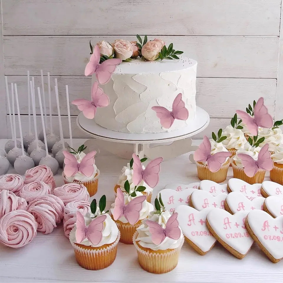 A display of pink butterfly cupcake toppers and cupcakes arranged on a white surface.