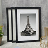 A set of three black wooden photo frames displaying a black and white image of the Eiffel Tower.